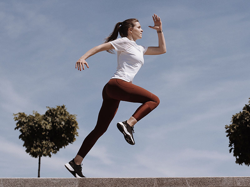 A woman running with arm swing